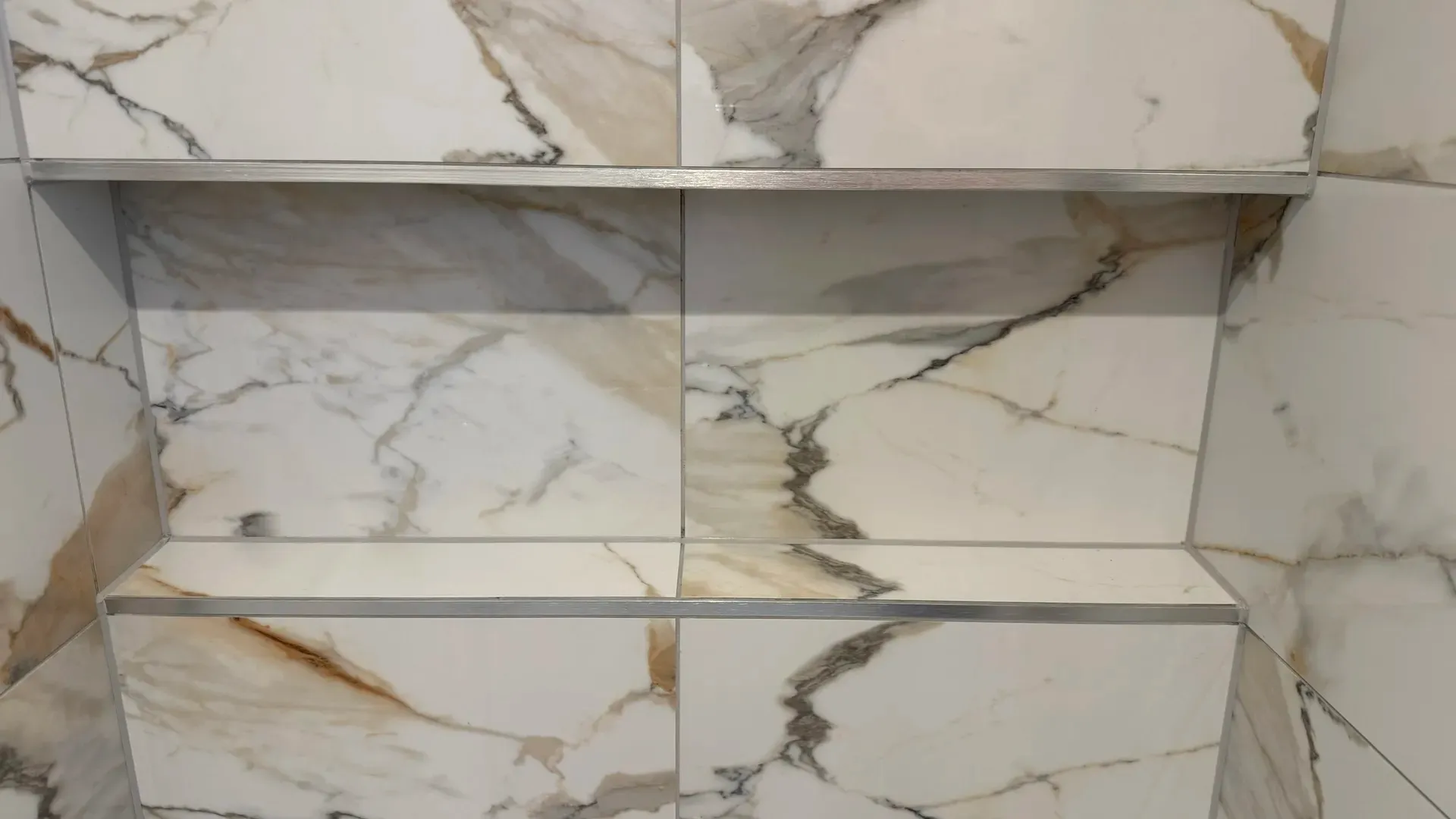 Marble-effect tiled recess with a slim shelf formed in the wall
