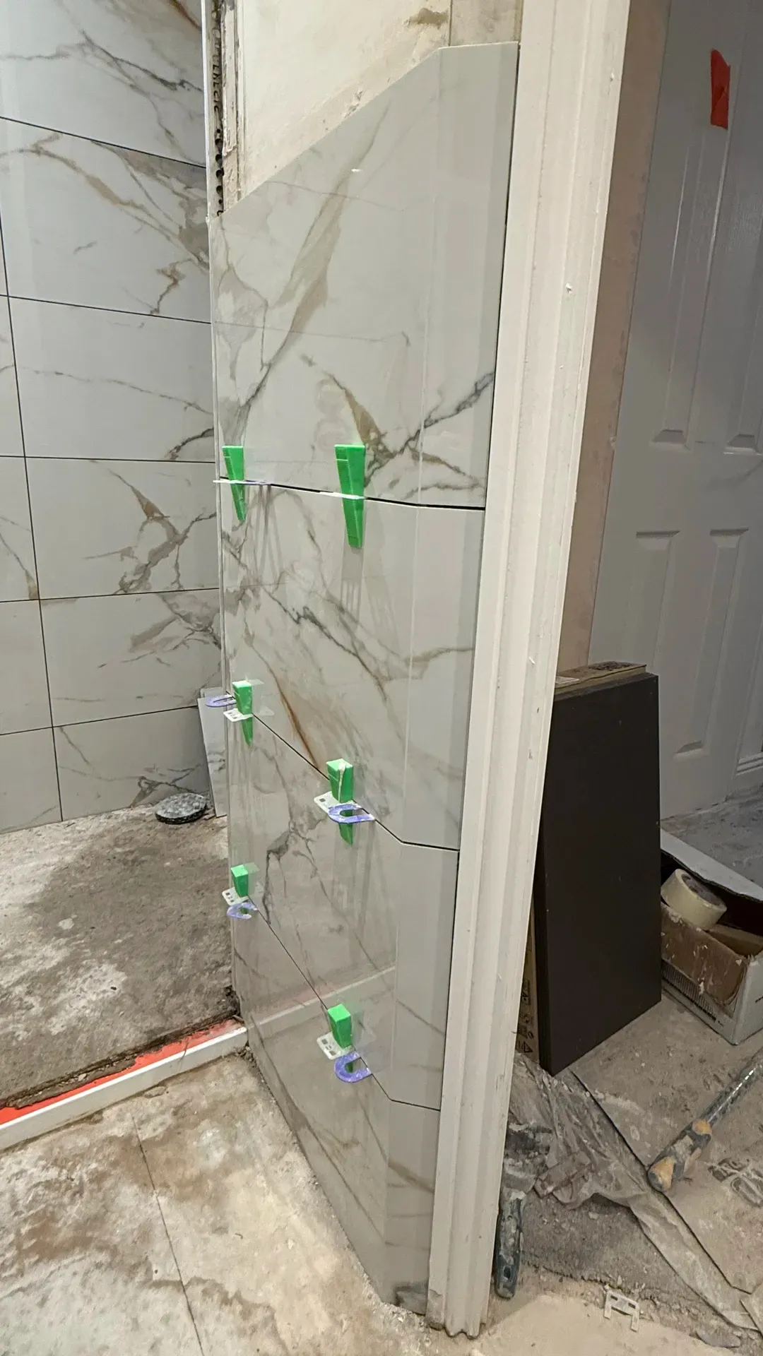 Wall tiles being set with levelling clips during a bathroom installation