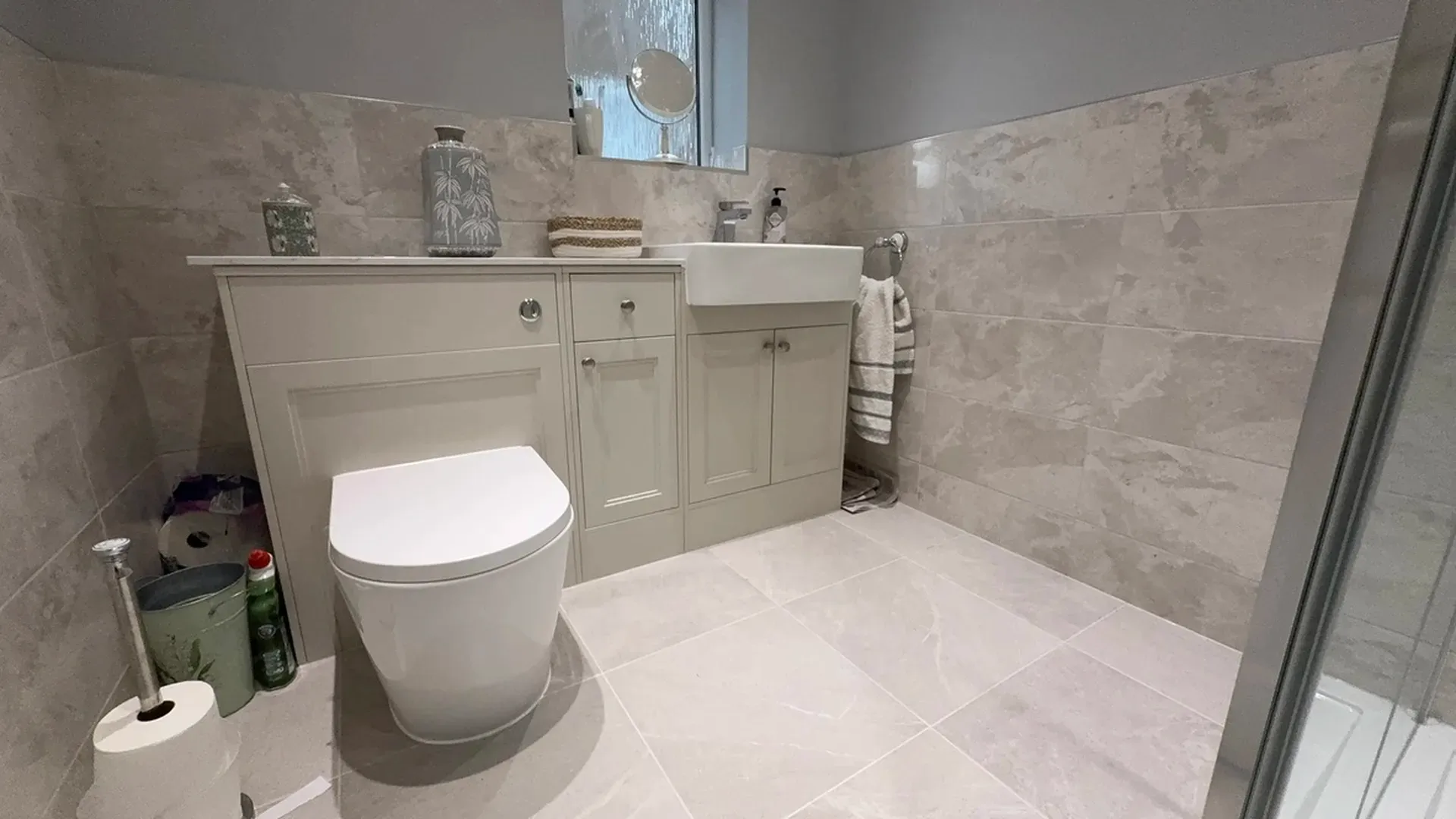 Fitted vanity units and a countertop basin in a half-tiled family bathroom