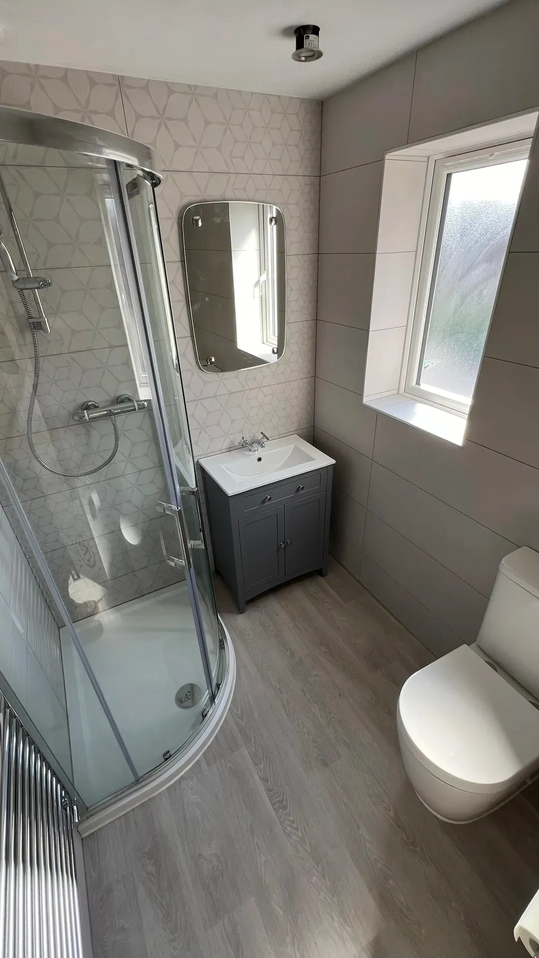 Shower enclosure and vanity unit under a sloping ceiling with roof windows