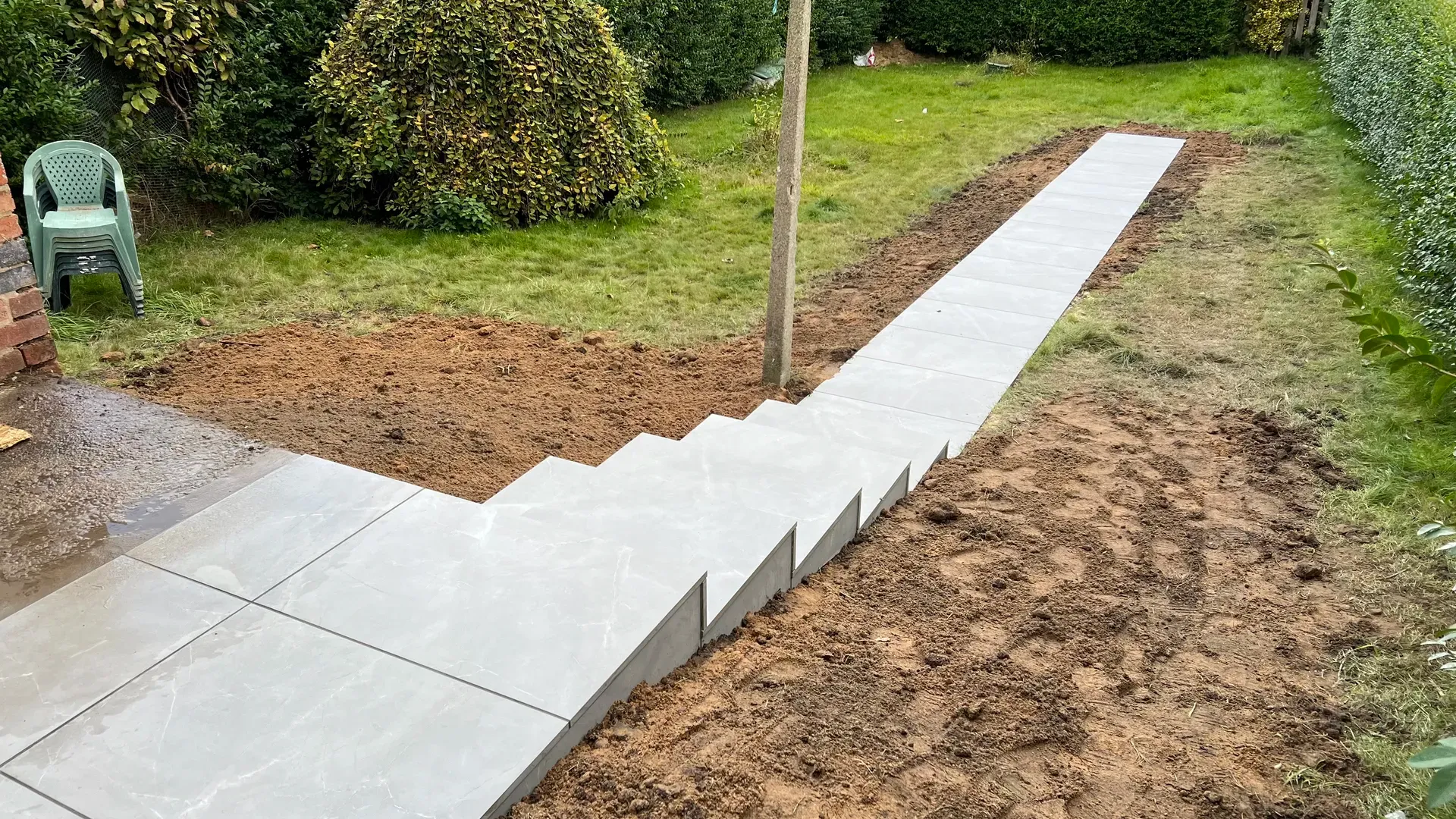 New concrete path and retaining edge laid across a garden