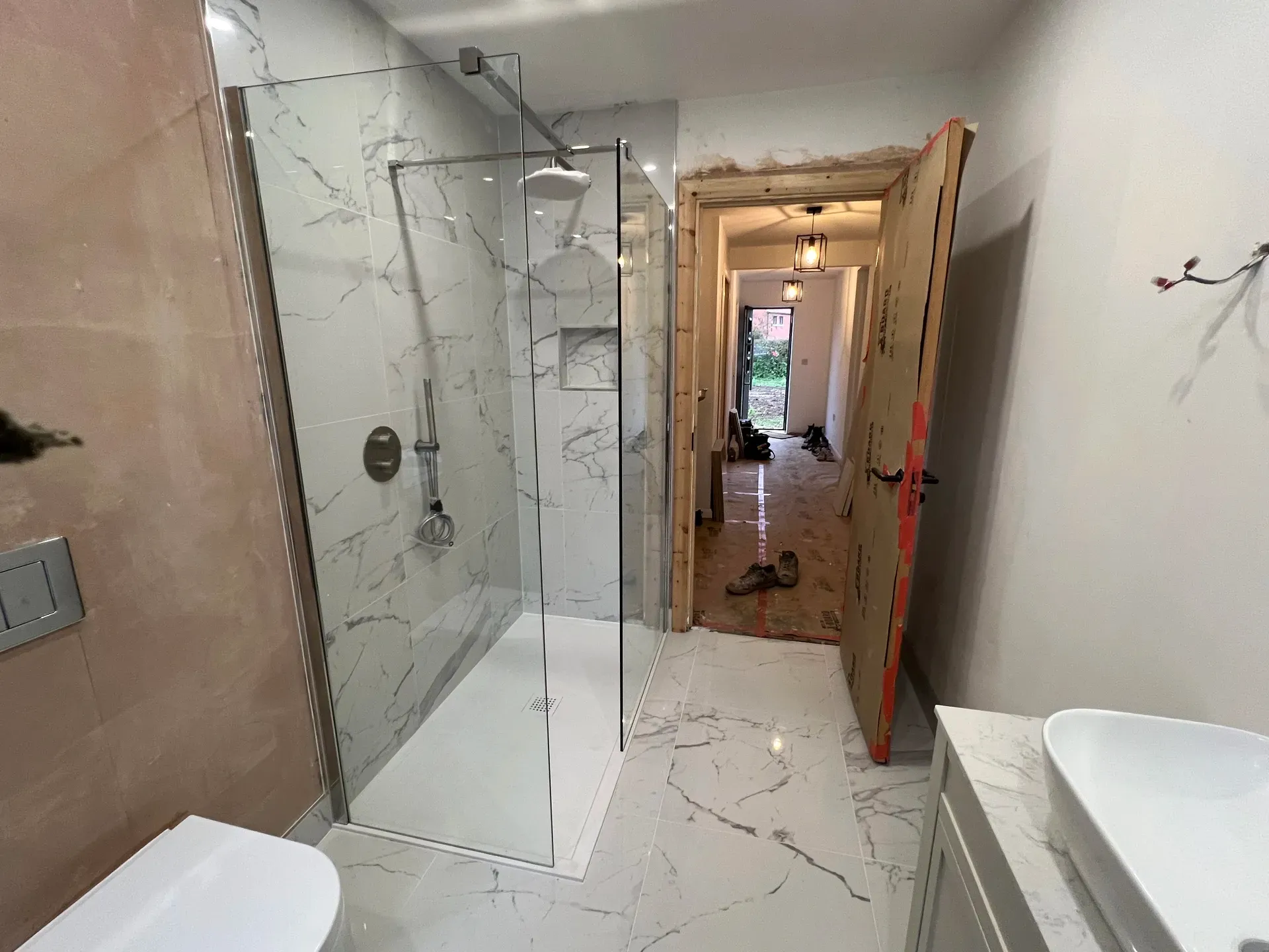 Walk-in shower opening onto a hallway during a full bathroom renovation