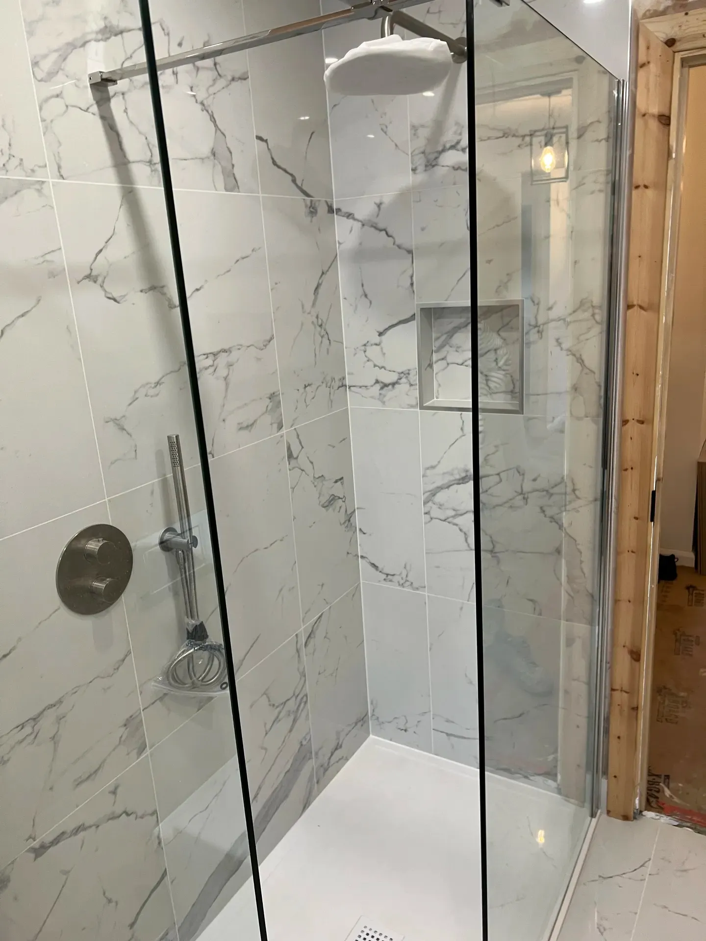 Walk-in shower screen and recessed niche part-way through tiling
