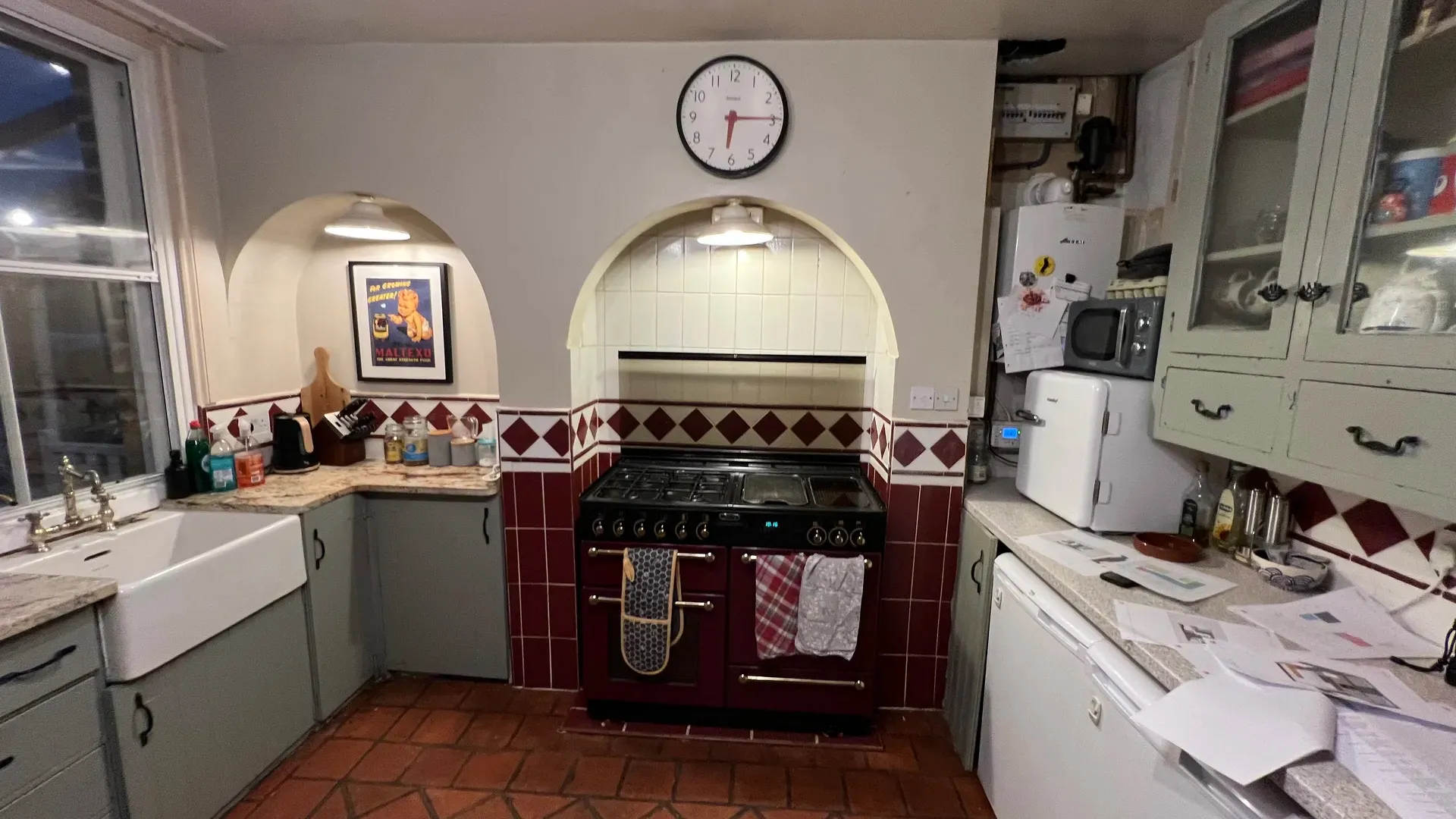 Original tiled kitchen with a range cooker in an arched recess, before renovation